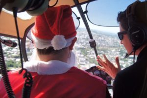 Papai Noel chega a Santiago de helicóptero e é recebido por crianças no Ginasião