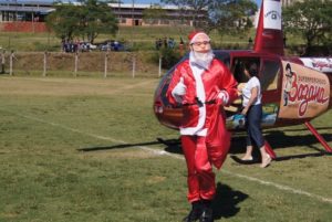 Papai Noel chega a Santiago de helicóptero e é recebido por crianças no Ginasião