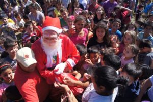 Papai Noel chega a Santiago de helicóptero e é recebido por crianças no Ginasião